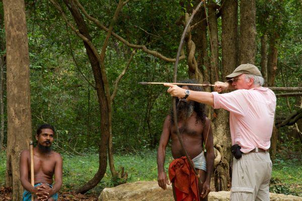 A visitor tries traditional archery with Vedda guides near Dambana, Sri Lanka
