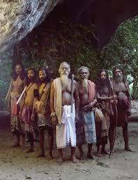 A group of Vedda elders standing at a cave entrance near Dambana, Sri Lanka